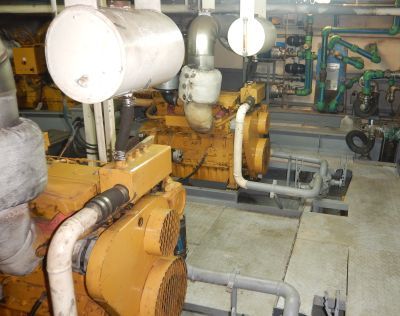 A large industrial machine room with pipes and valves.