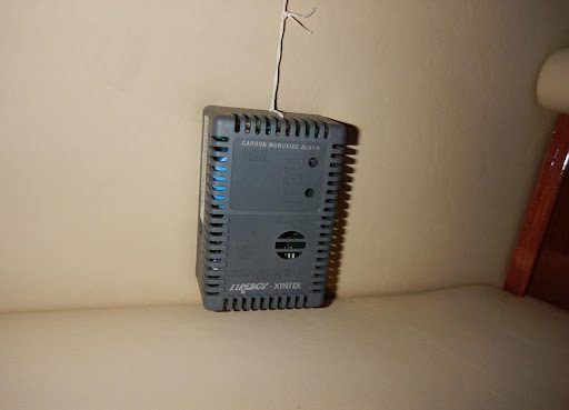 A small device is hanging on the wall.