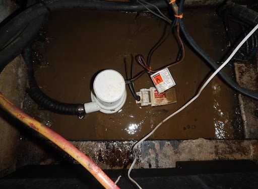 A dirty floor with wires and electrical equipment.